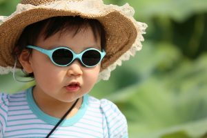 little girl with sunglasses and frilly hat