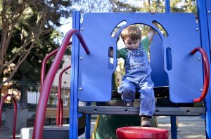 Little boy on playground equipment