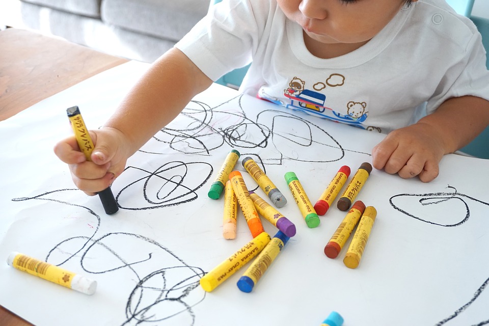Child drawing with thick crayons