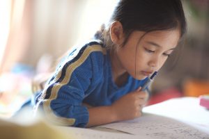 Young girl reading a book at preschool