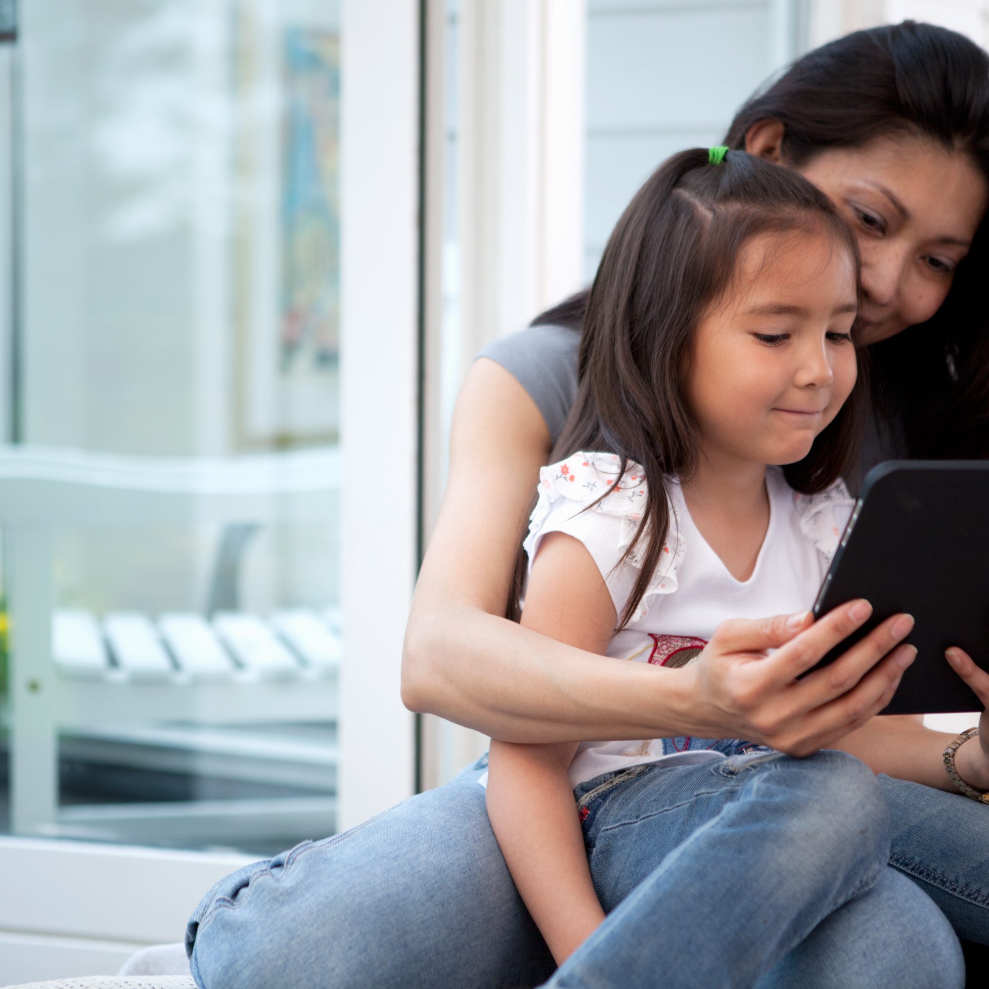 Mother reading on a tablet with her child