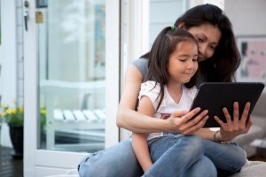 Mother reading on a tablet with her child