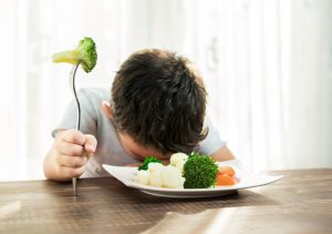 Boy Resisting Eating His Vegetables