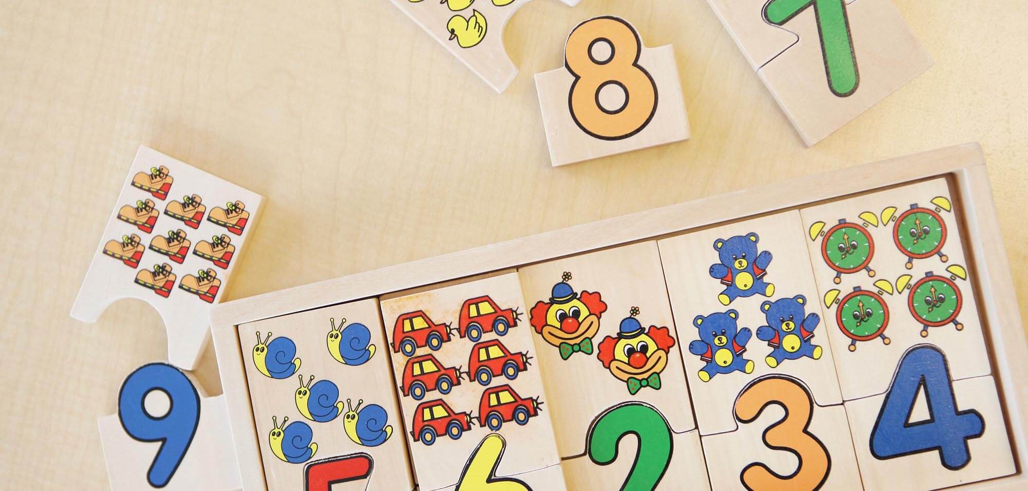 Numbers and math cards shown on a table in the shape of puzzle pieces